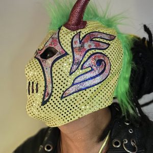 Esta pieza es una explosión de color y texturas. Perfecta para el luchador que busca una identidad visual caótica y moderna. La combinación de amarillo, verde y bordes en azul profundo rompe con todos los esquemas tradicionales de la lucha libre.