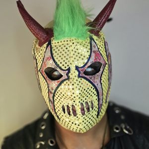 Esta pieza es una explosión de color y texturas. Perfecta para el luchador que busca una identidad visual caótica y moderna. La combinación de amarillo, verde y bordes en azul profundo rompe con todos los esquemas tradicionales de la lucha libre.