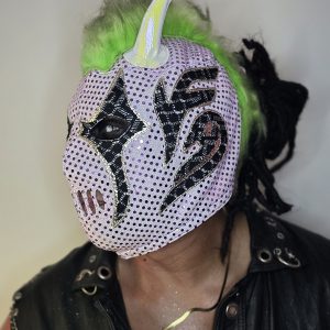 Máscara Pro-Wrestling "Neon Virus" – Lavender & Acid Green Edition Rompe la estética tradicional con un diseño que grita modernidad. Esta máscara utiliza una base lila metalizada con textura de micro-puntos que refleja la luz de forma multidimensional, combinada con detalles que evocan una naturaleza digital y peligrosa.