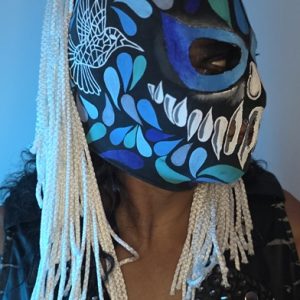 Máscara "Hummingbird Trauma II" – Edición Spectral Abyss La Hummingbird Trauma II es la evolución de la mística en el ring. Esta versión frontal destaca por un diseño de "máscara dentro de otra máscara", donde el antifaz azul eléctrico parece emerger de un cráneo ancestral negro. Es una pieza que proyecta autoridad y un misterio insondable.