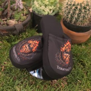 Pantuflas Traumas.mx – Edición "Skull on Fire" Dales a tus pies el alivio que necesitan después de la batalla. Estas pantuflas combinan la calidez de un calzado de descanso con el diseño agresivo de Traumas.mx, presentando la icónica máscara envuelta en llamas sobre un fondo negro sólido.