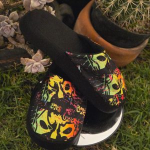 Pantuflas Traumas.mx – "Home Rudo Home" Dales a tus pies el descanso que se merecen con las nuevas Pantuflas de Traumas.mx. Este modelo ha sido creado para los fanáticos que buscan confort sin sacrificar la identidad de la Dinastía Navarro. Con una silueta clásica y fácil de usar, estas pantuflas destacan por su llamativo estampado de máscaras de lucha libre en colores neón, diseñado para vibrar en cualquier entorno doméstico.